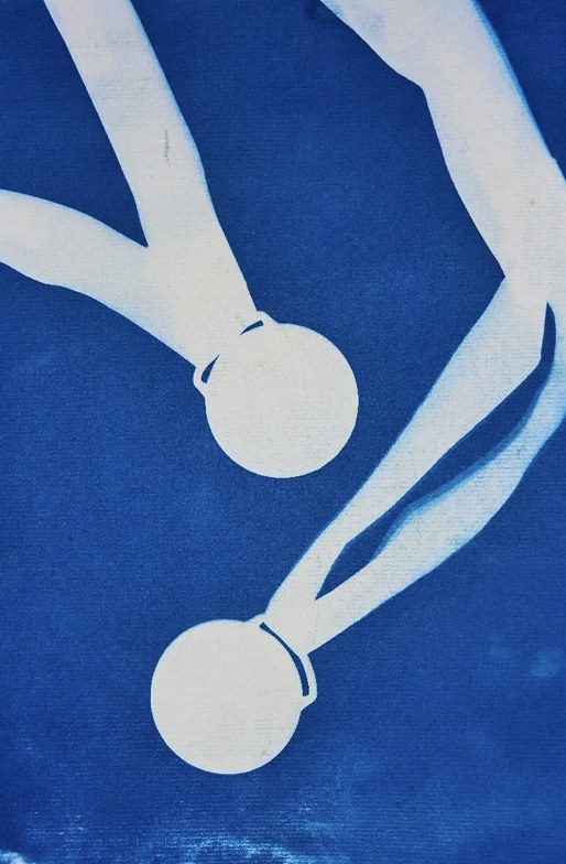 Cyanotype print of two medals on their ribbons