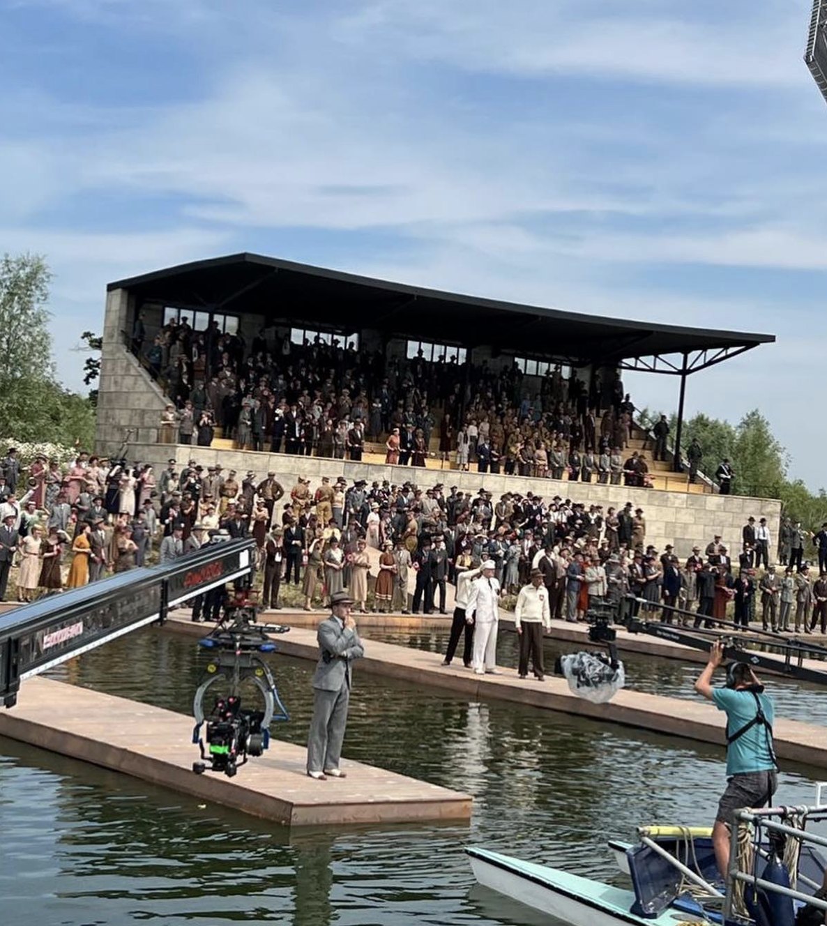 The 1936 Berlin grandstand set, with extras in period dress and camera cranes over the water