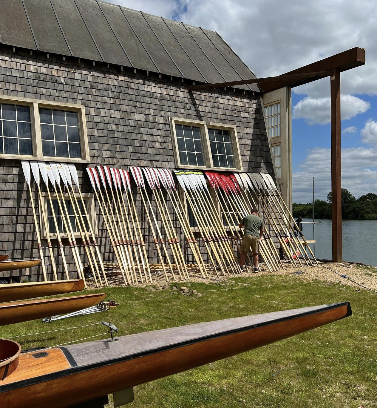 Period oars painted in crew colours, dressed for camera outside the boathouse set
